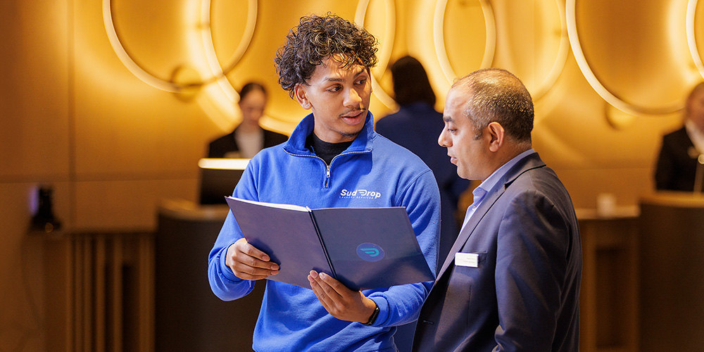 A student showing someone a folder.