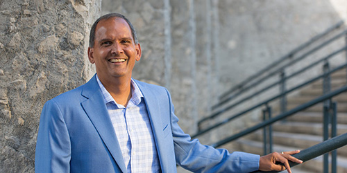 Dr. Michael Khan stands with his hand on a banister.